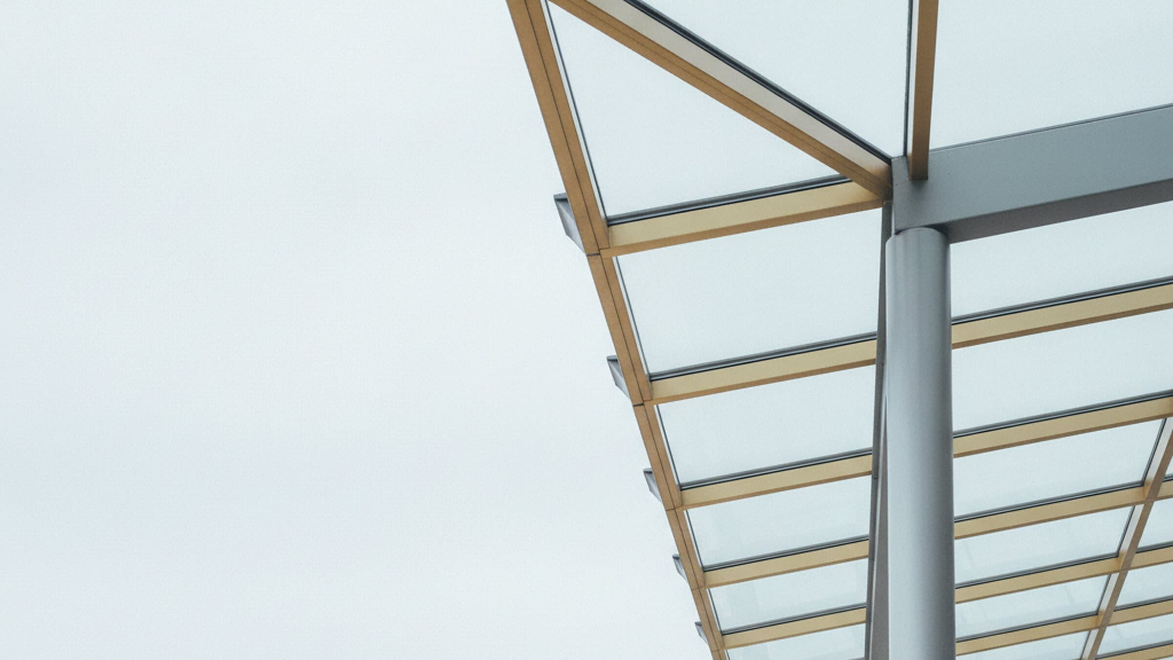Aluminium-Glasdach von unten gegen den hellen Himmel