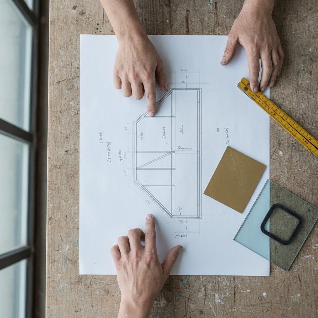 Technische Zeichnung und Materialmuster auf dem Werkstatttisch
